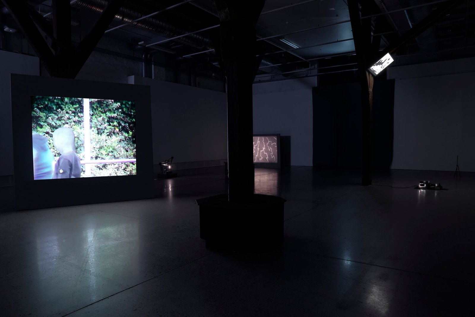 Installation view with digital and analogue projections and public-park-style furniture by Anna Clawson